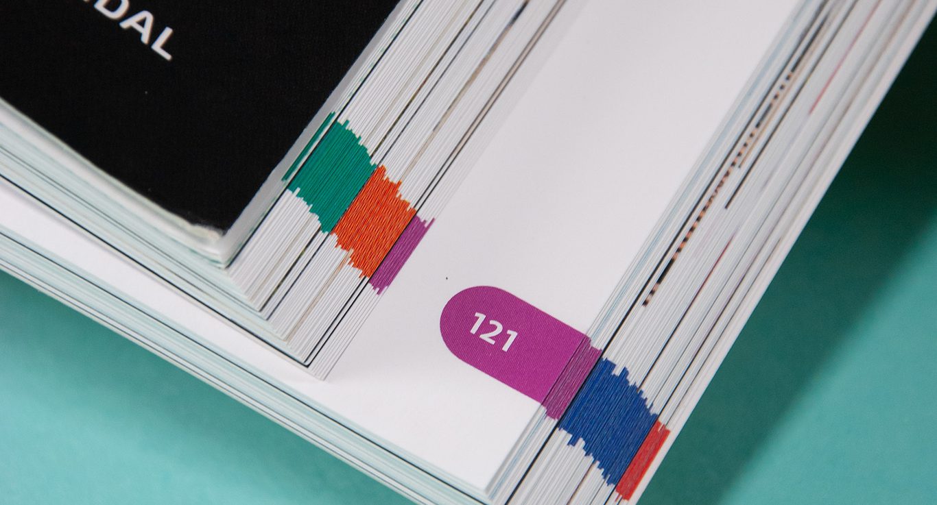 Bildet viser sidetallene i boken sett fra kanten av boken. Sidetallene har hver sin bakgrunnsfarge.